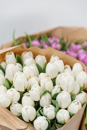 beautiful bunch of white and lilac tulips in kraft paper. Present for a girl.の写真素材