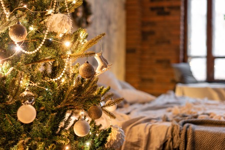 Fir Branches decorated in the foreground. Loft apartments, brick wall with candles and Christmas...