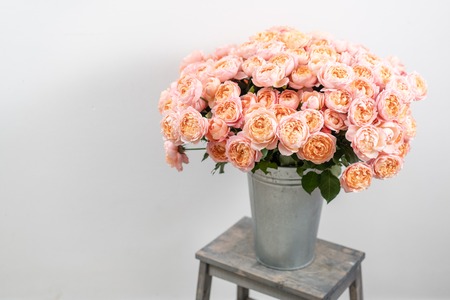 Big luxury bright bouquet peony rose on wooden table. Garden spray roses of pink and peach color . bouquet in metal vaseの写真素材
