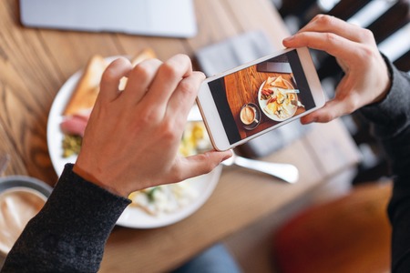 Blogger takes pictures of the Breakfast on the smartphone. Concept of creating content for social...