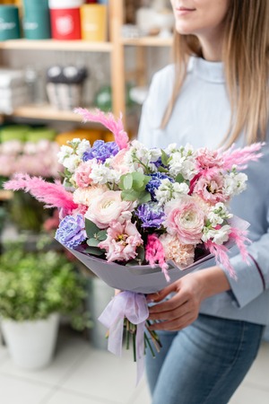 European floral shop. Bouquet of beautiful Mixed flowers in woman hand. Excellent garden flowers in the arrangement , the work of a professional florist.の写真素材