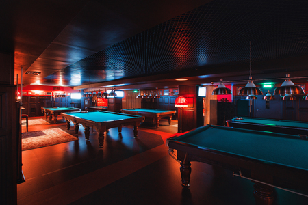 Russia, Nizhny Novgorod - may 26, 2014: Sormovsky Cinema and Entertainment center. Interior of a club having billiard tables illuminated with lights. large green pool tableのeditorial素材
