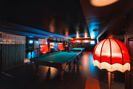 Russia, Nizhny Novgorod - may 26, 2014: Sormovsky Cinema and Entertainment center. Interior of a club having billiard tables illuminated with lights. large green pool tableのeditorial素材