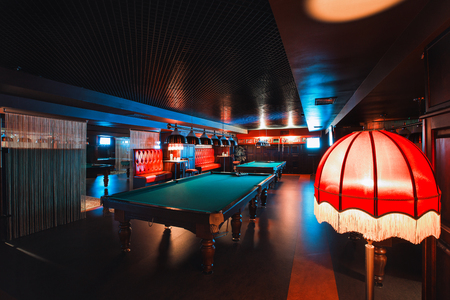 Russia, Nizhny Novgorod - may 26, 2014: Sormovsky Cinema and Entertainment center. Interior of a club having billiard tables illuminated with lights. large green pool table