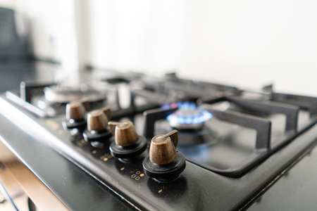 Closeup shot of blue fire from domestic kitchen hob. Gas cooker with burning flames propane gas.の写真素材