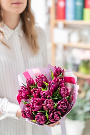 Bouquets of violet tulips. Spring flowers from Dutch gardener. Concept of a florist in a flower shop. Wallpaper.の写真素材