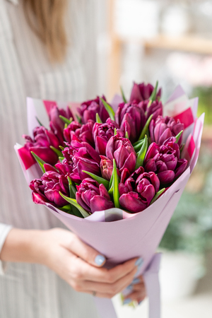 Bouquets of violet tulips. Spring flowers from Dutch gardener. Concept of a florist in a flower shop. Wallpaper.の写真素材
