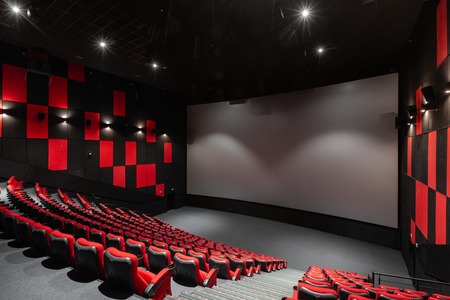 Russia, Nizhny Novgorod - November 14, 2016: Cinema Imperia Grez Nebo, Dolby Atmos. Empty red cinema hall seats, comfortable and soft chairs. Perspective auditorium view with white space on the screenのeditorial素材