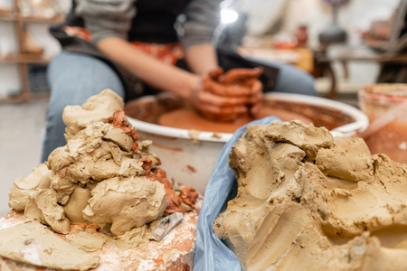 Craftsman hands making pottery bowl. Woman working on potter wheel . Family business shop sculpts pot from clay view top.の写真素材