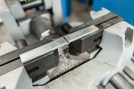vise to secure the workpiece. Circular saw machine. Cutting a metal and steel with with sharp,...