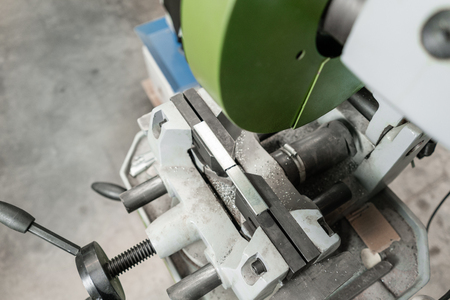 vise to secure the workpiece. Circular saw machine. Cutting a metal and steel with with sharp,...