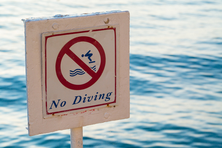 No diving. little depth and big stones the ban on diving. Summer sunrise on coast, Corfu island, Greece.の写真素材