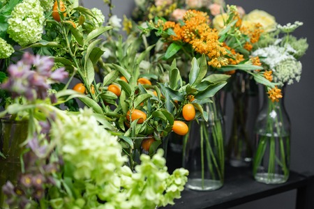 Flower shop concept. Glass vases with different colors on the shelves of the refrigerator showcases. Abstract background of flowers. Flowers composition.の写真素材