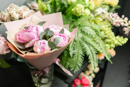 Flower shop concept. Glass vases with different flowers on the shelves of the refrigerator showcases. Abstract background of floral. Flowers composition.の写真素材