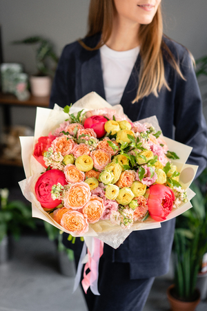 Beautiful bouquet of mixed flowers in woman hand. Floral shop concept . Beautiful fresh cut bouquet. Flowers deliveryの写真素材