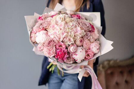Pink peonies and hydrangea. Beautiful bouquet of mixed flowers in woman hand. Floral shop concept . Handsome fresh bouquet. Flowers delivery. Red and pink color.の写真素材