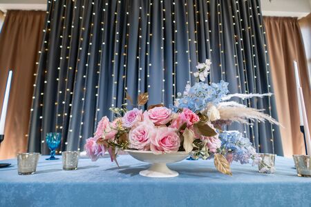 luxury dinner Banquet in the restaurant. Beautiful and exquisite decoration of the wedding celebration. Banquet served table with a beige pink tablecloth, plates and candlesticks with candles.の写真素材
