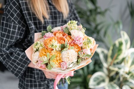 Beautiful bouquet of mixed flowers in woman hand. Floral shop concept . Handsome fresh bouquet. Flowers delivery.の写真素材
