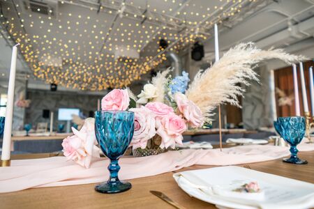 luxury dinner Banquet in the restaurant. Beautiful and exquisite decoration of the wedding celebration. Banquet served table with a beige pink tablecloth, plates and candlesticks with candles.の写真素材
