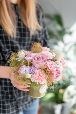 Beautiful bouquet of mixed flowers in woman hand. Floral shop concept . Handsome fresh bouquet. Flowers delivery.の写真素材