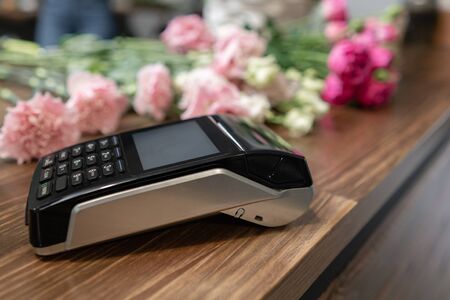 Concept contactless payment. Making payment with smartphone and pos terminal, printed check. Floral...