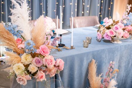 Blue tablecloth, plates and candlesticks with candles. Luxury dinner Banquet in the restaurant. Beautiful and exquisite decoration of the wedding celebration.の写真素材