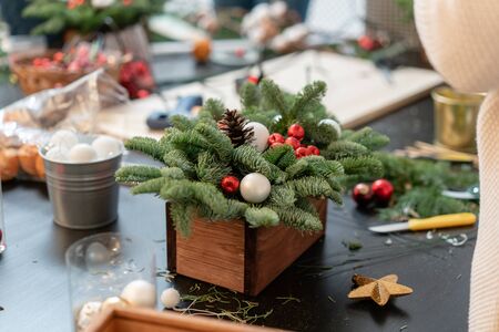 Christmas decor with their own hands. Woman created a xmas arrangement. Master class on making decorative ornaments. Flower shopの写真素材