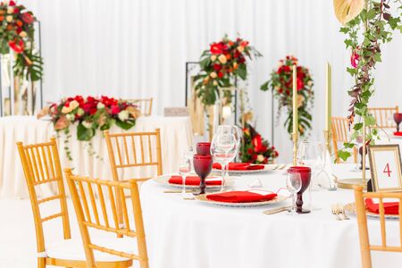 Beautiful banquet hall under a tent for a wedding reception. Interior of a wedding tent decoration ready for guests. Decor flowers. Red themeの写真素材