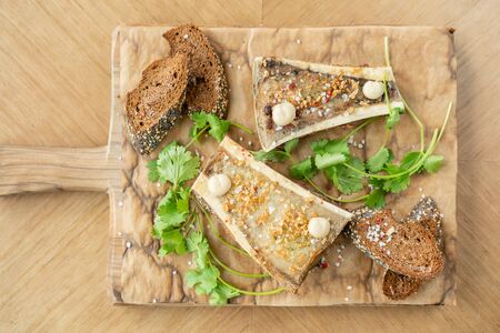 Beef bone marrow with chimichurri sauce and toasted bun. Served on a chopping wooden Board. Menu BBQ...