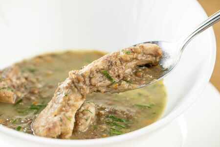 A bowl of homemade chili lentil soup with meat on wooden table. Restaurant menuの写真素材
