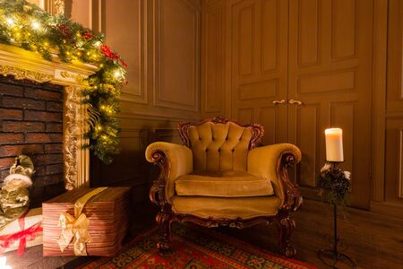 Christmas evening by candlelight. classic apartments with a fireplace, decorated tree, armchair.の写真素材