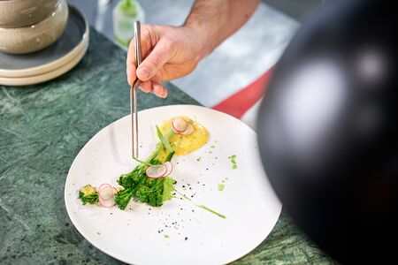 The chef serves the dish Salmon steak fillet and garnished with young broccoli. Restaurant menu, a series of photos of different dishesの写真素材