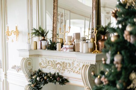 Christmas morning. Classic luxurious apartments with decorated christmas tree and presents. Living with fireplace, columns and stucco.の写真素材