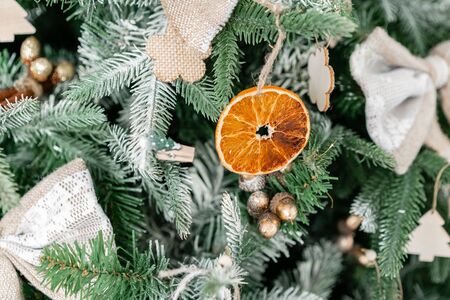 Close-up branches of Christmas tree with ornaments. Christmas balls, ribbon bow, snowflakes, pine cones and lights.の写真素材