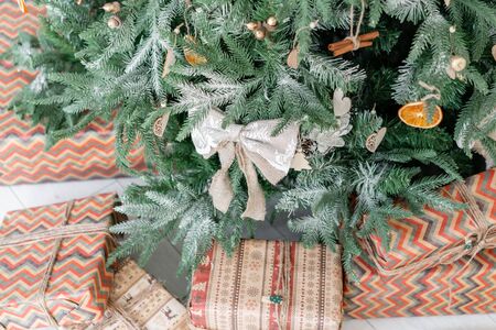 Close-up branches of Christmas tree with ornaments. Christmas balls, ribbon bow, snowflakes, pine cones and lights.の写真素材