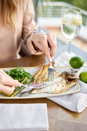 Roasted pike perch or cod fish with baked vegetables. Dish decorated with a slice of lemon. Restaurant menu.の写真素材