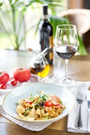 Italian pasta with seafood and tomato sauce. Pasta Gamberini. Close-up tagliatelle wind it around a fork with a spoon. Parmesan cheeseの写真素材