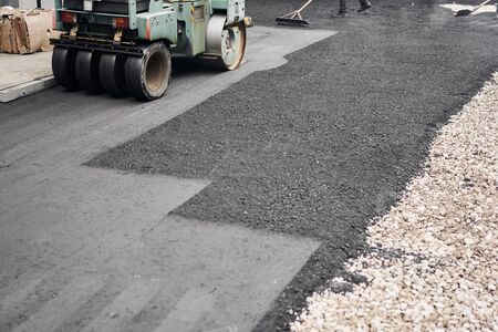 Asphalt Compactors is carrying out road repair work. Laying new asphalt. Large heavy machinery. Construction of a new asphalt road.の写真素材
