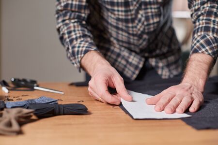 Tailor cutting wool fabric. the line pattern. Craftsman Makes rectangular blanks for Bow ties of...