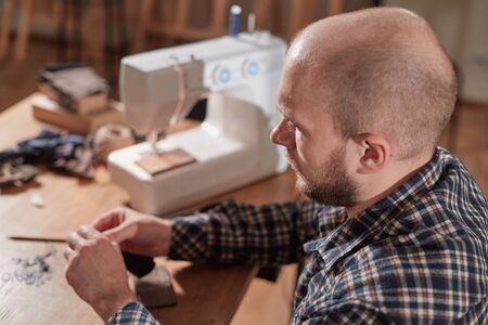 Tailor makes bow ties of woolen fabric. Work with sewing machine in a textile studio.の写真素材