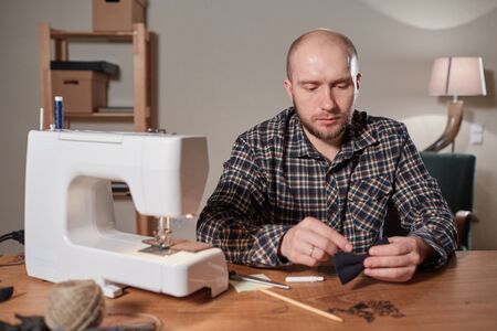 Tailor makes bow ties of woolen fabric. Work with sewing machine in a textile studio.の写真素材