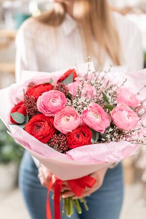 Beautiful bouquet of mixed flowers in womans hands. the work of the florist at a flower shop. Handsome fresh bouquet. Flowers deliveryの写真素材