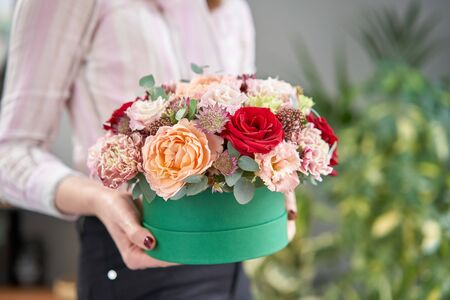 European floral shop. Floral bunch in round box. Bouquet of beautiful Mixed flowers in woman hand. Excellent garden flowers in the arrangement , the work of a professional florist.の写真素材