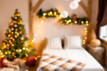 Abstract blur. Xmas in morning living room. Sofa bed In christmas Interior. celebrate the new year and holidays. Christmas tree and gingerbread houseの写真素材