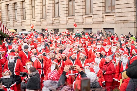 Riga, Latvia - December 08 2019. Unidentified participants of annual Santas Fun Run & Walk on December. Riga Santas Race start on Christmas market on Dome Square, in the Old Town.のeditorial素材