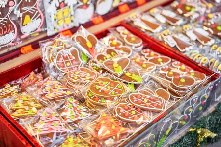 Ginger cookies of different shapes. Gingerbread man and christmas mood in blurred background. Christmas market in old town European small city.の写真素材