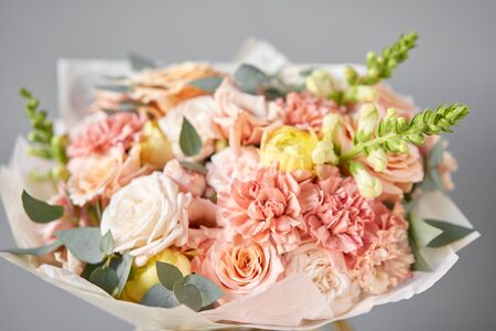 European floral shop. Beautiful bouquet of mixed flowers in glas vase. the work of the florist at a flower shop. Delivery fresh cut flower.の写真素材