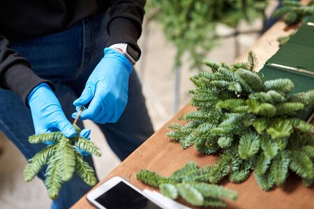A woman decorates a Christmas arrangement. Master class on making decorative ornaments. Christmas...