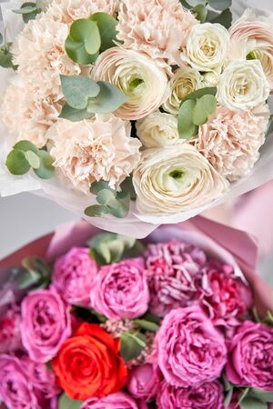 Two Beautiful bouquets of mixed flowers in womans hands. the work of the florist at a flower shop. Delivery fresh cut flower. European floral shop.の写真素材