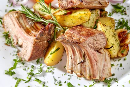 Grilled rack of lamb with fried potatoes and fresh vegetables,